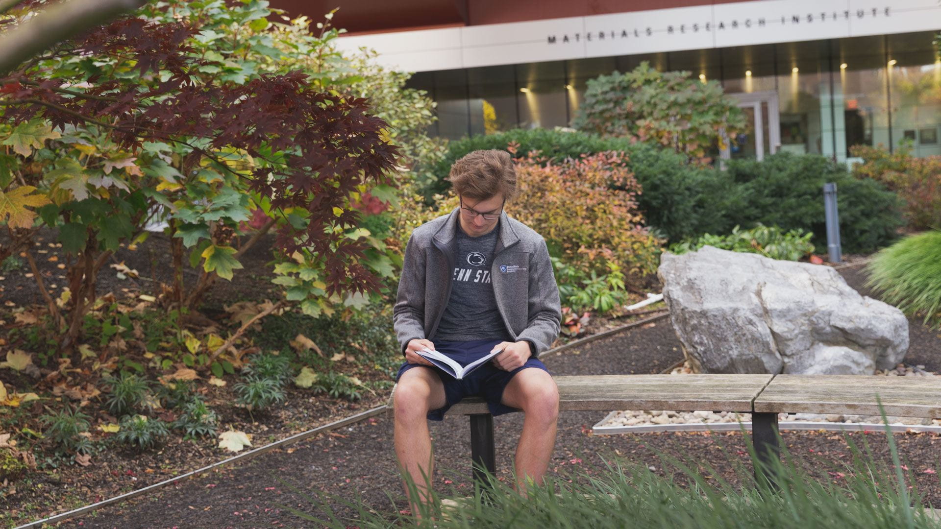 Joshua Reynolds reading a book near the Millennium Sciences Complex.